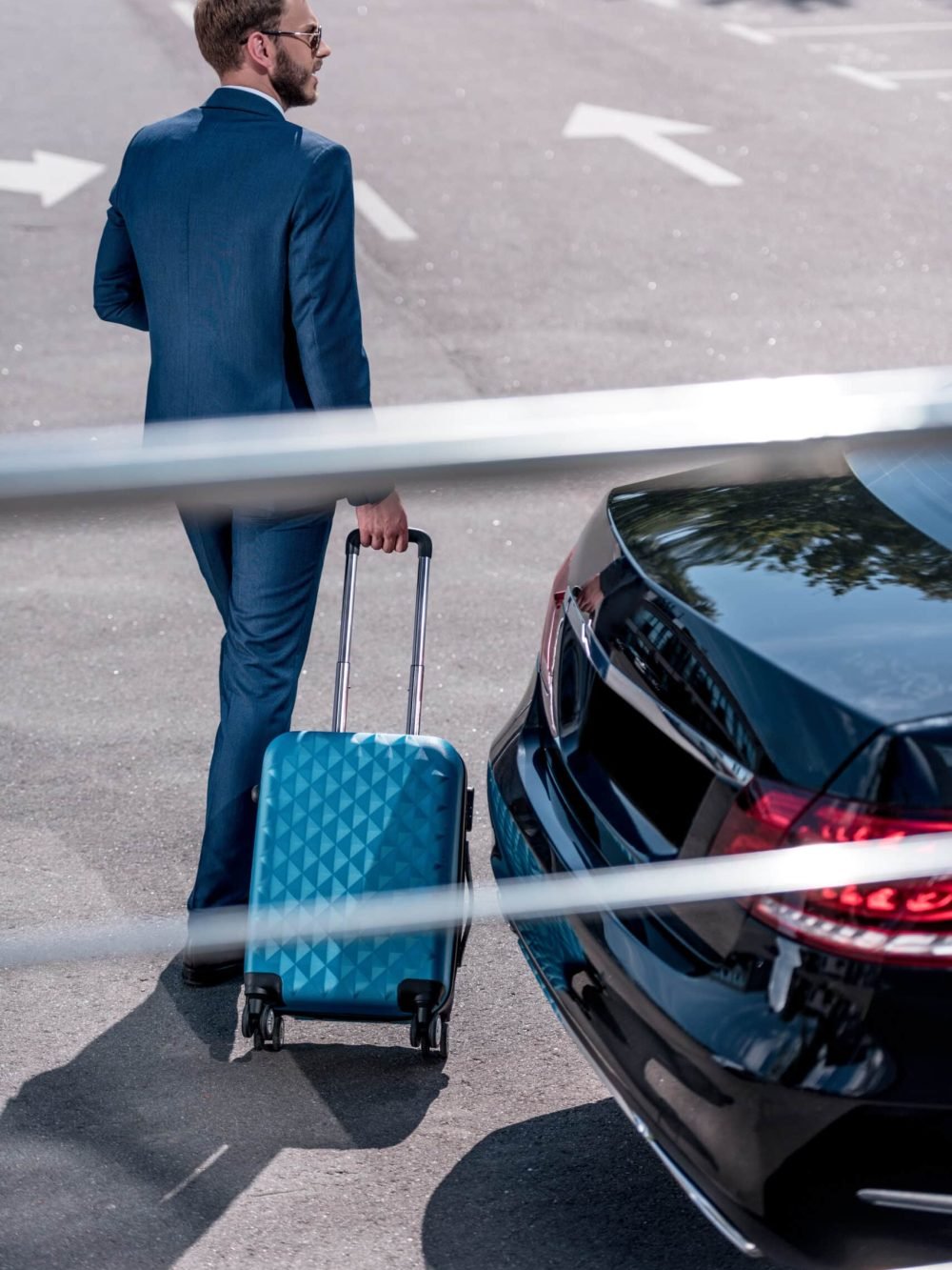 businessman in suit with suitcase for business trip at car
